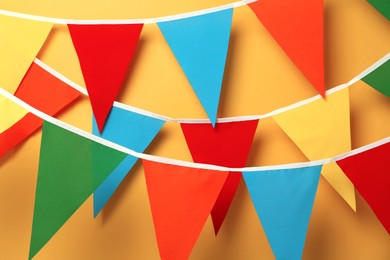 Photo of Buntings with colorful triangular flags on orange background
