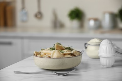 Photo of Delicious dumplings with dill on table in kitchen, space for text