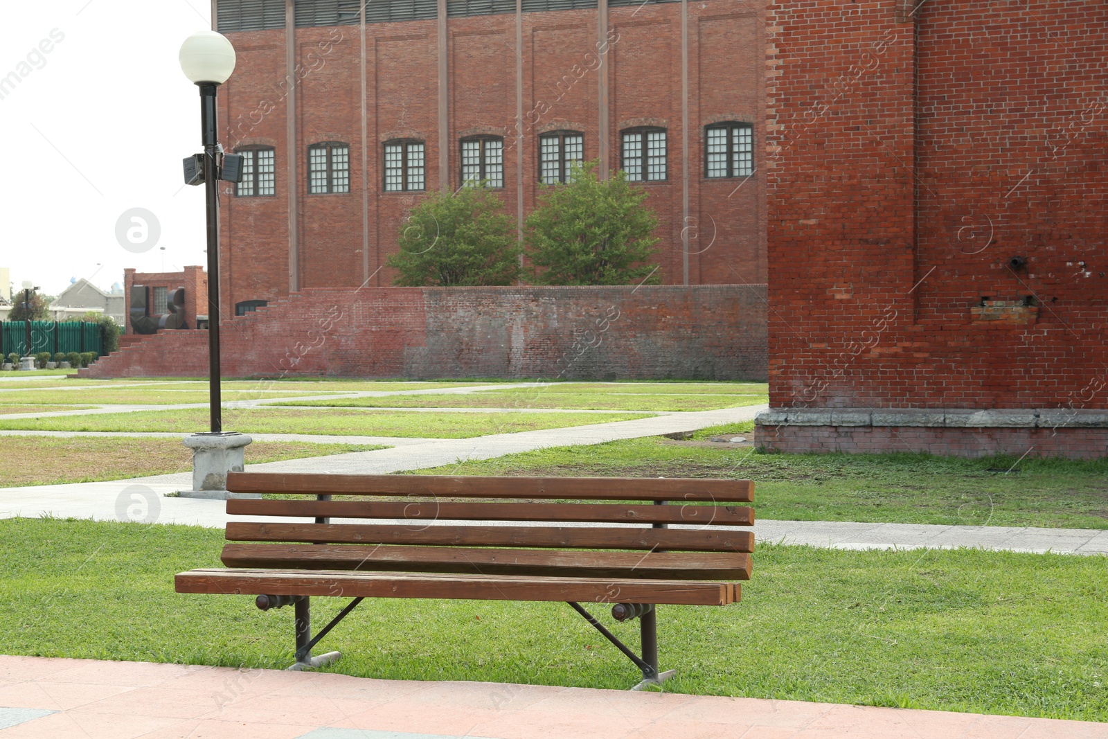 Photo of Stylish wooden bench in park on sunny day