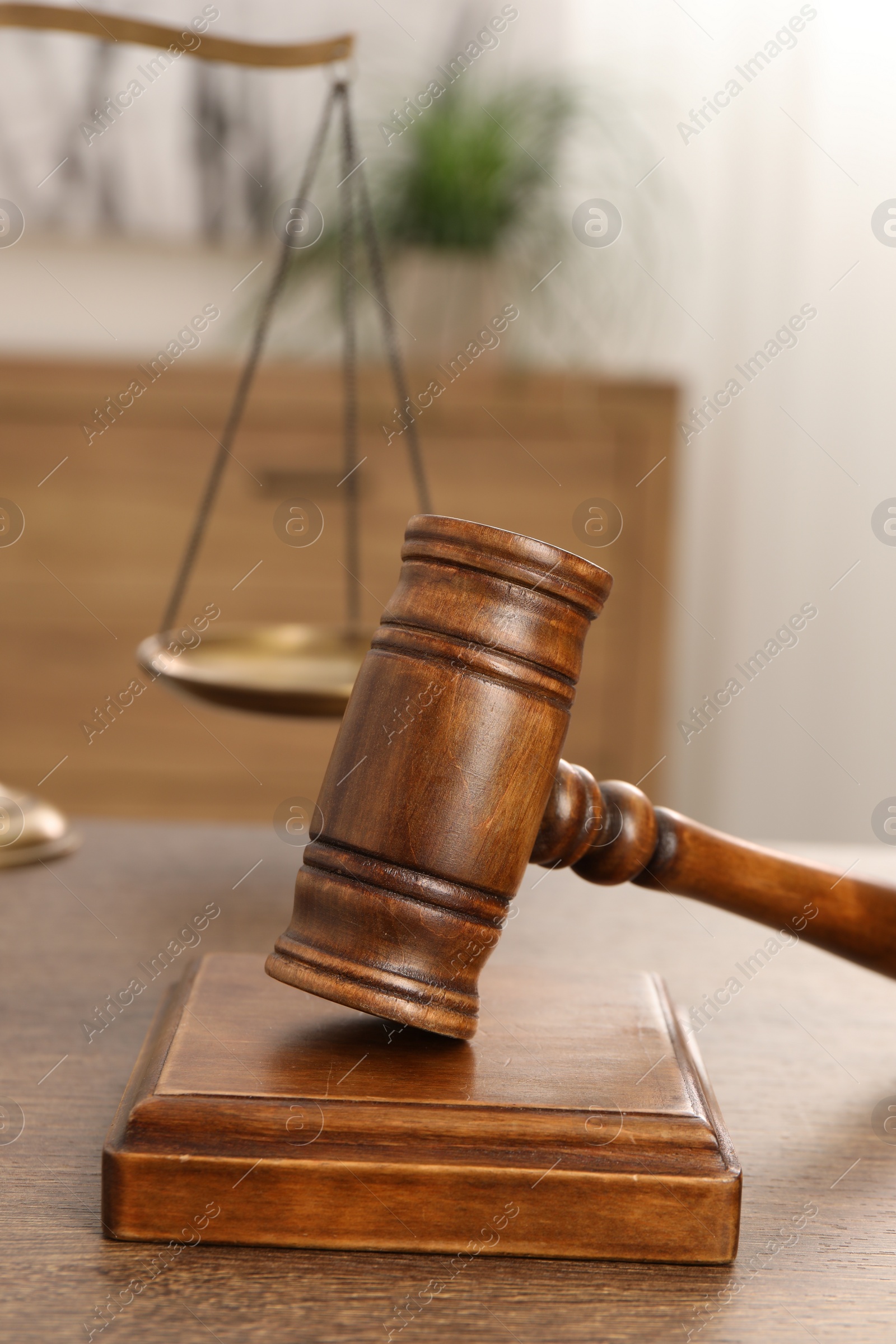 Photo of Wooden gavel and sound block on table indoors, closeup