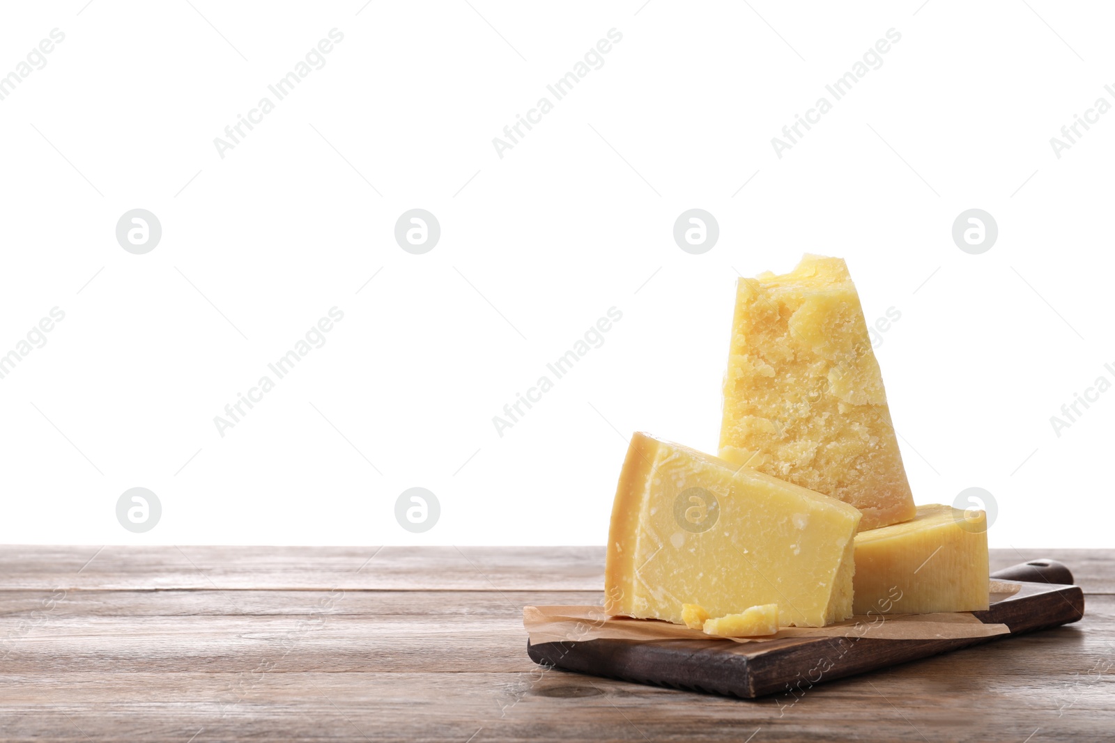 Photo of Pieces of delicious parmesan cheese on wooden table against white background. Space for text