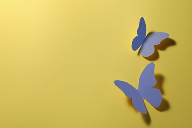 Image of Bright blue paper butterflies on yellow background