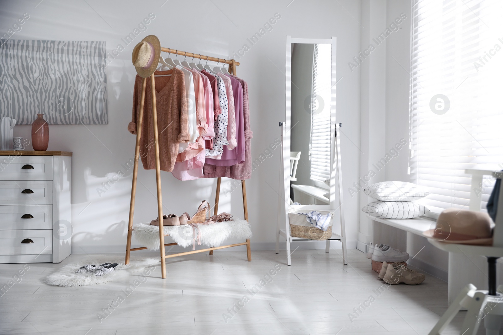 Photo of Rack with stylish women's clothes indoors. Interior design