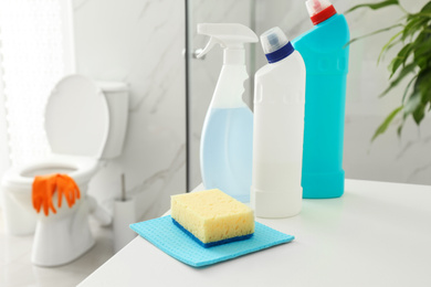 Photo of Cleaning supplies and toilet bowl in bathroom. Space for text