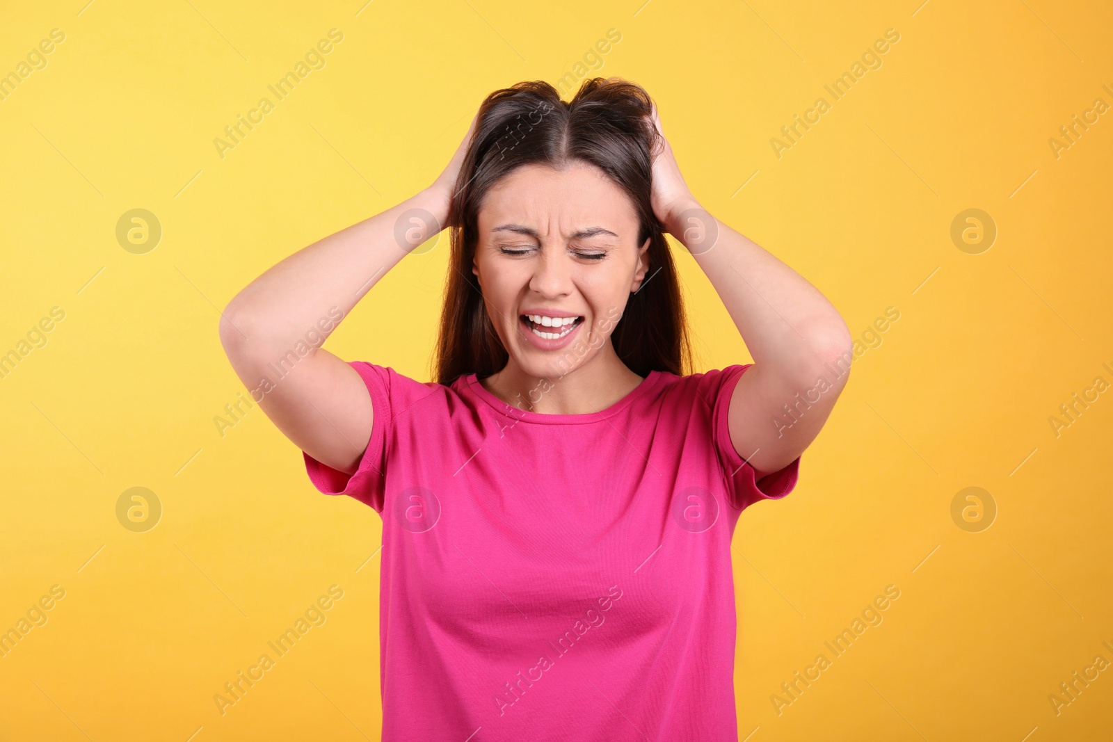 Photo of Portrait of stressed young woman on yellow background