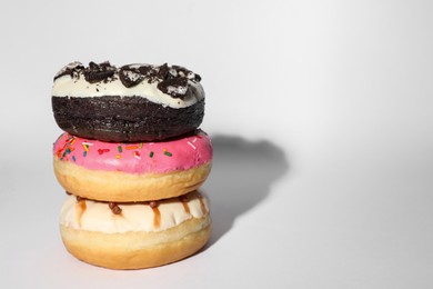 Photo of Sweet tasty glazed donuts on white background, space for text