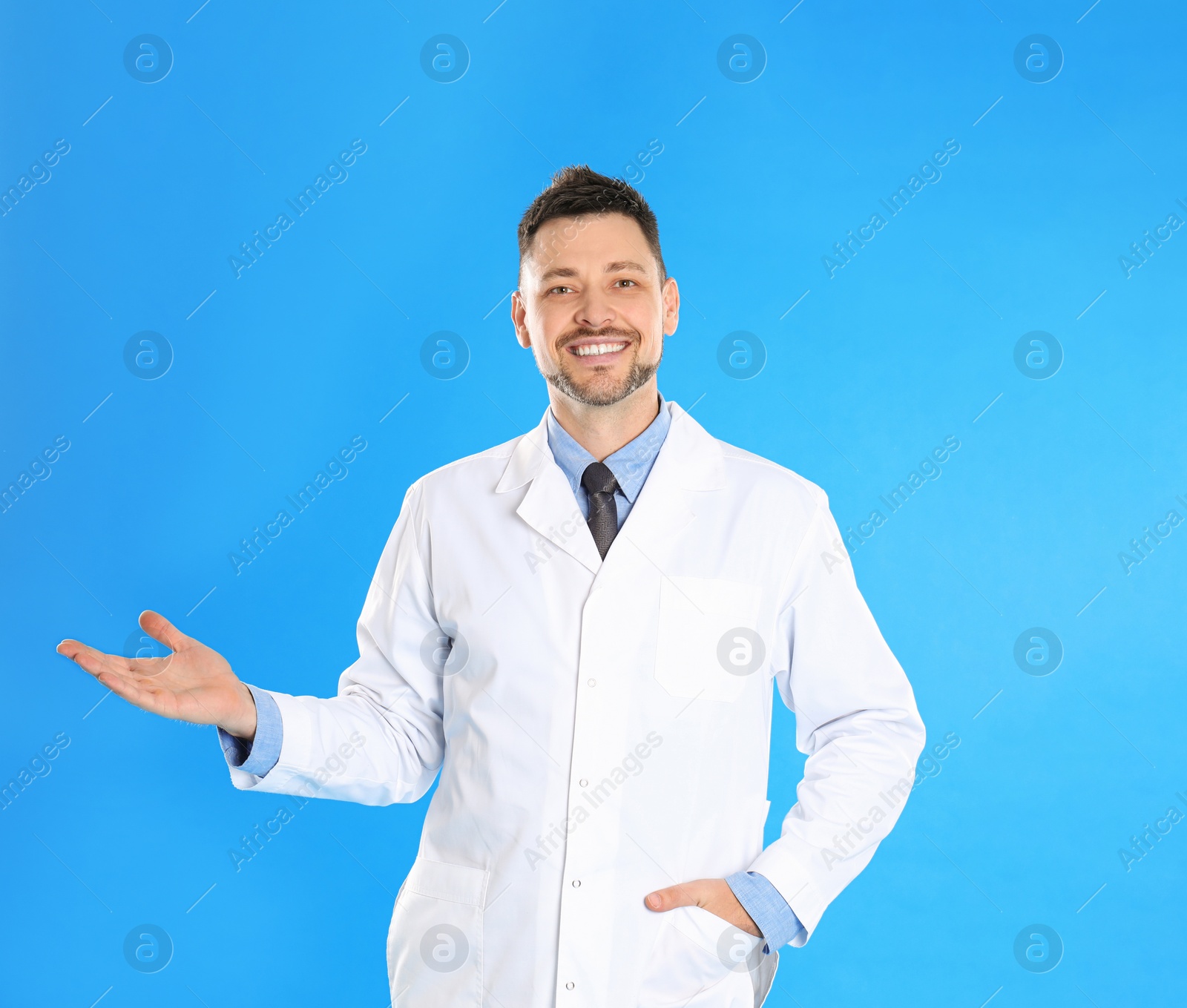 Photo of Happy man in lab coat on light blue background