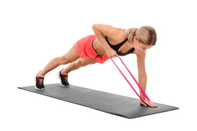 Photo of Woman exercising with elastic resistance band on fitness mat against white background