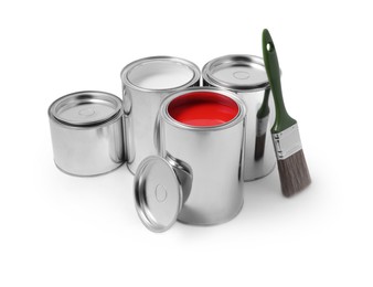 Photo of Cans of color paints and brush on white background
