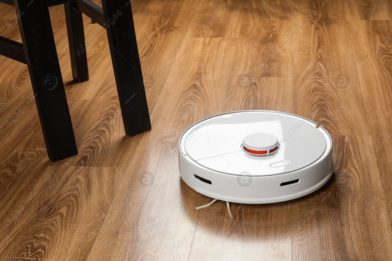 Photo of Robotic vacuum cleaner on wooden floor indoors