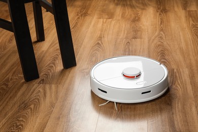 Robotic vacuum cleaner on wooden floor indoors
