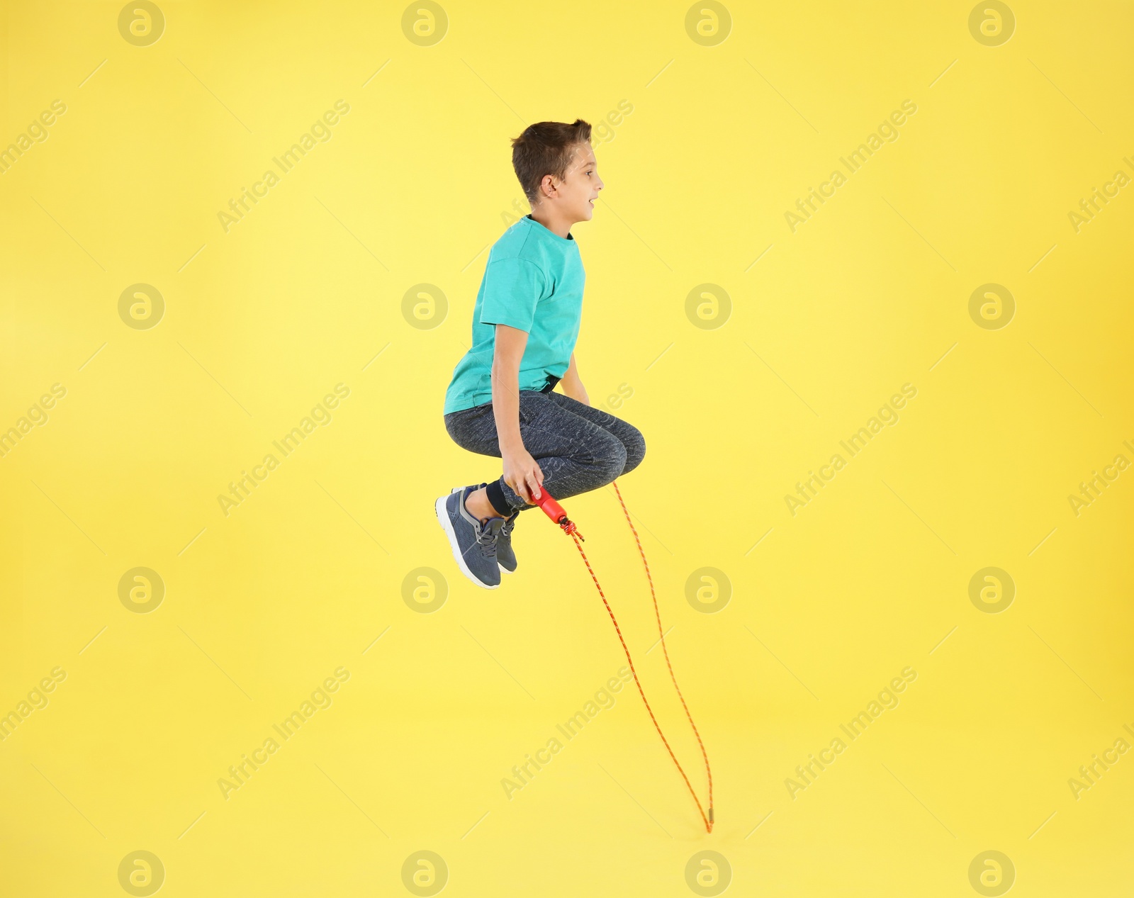 Photo of Active boy jumping rope on color background