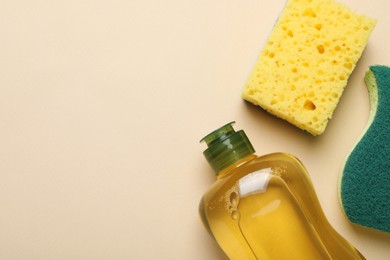 Photo of New sponges and detergent on beige background, flat lay. Space for text