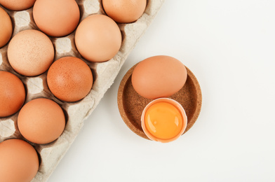 Photo of Raw chicken eggs on white background, top view