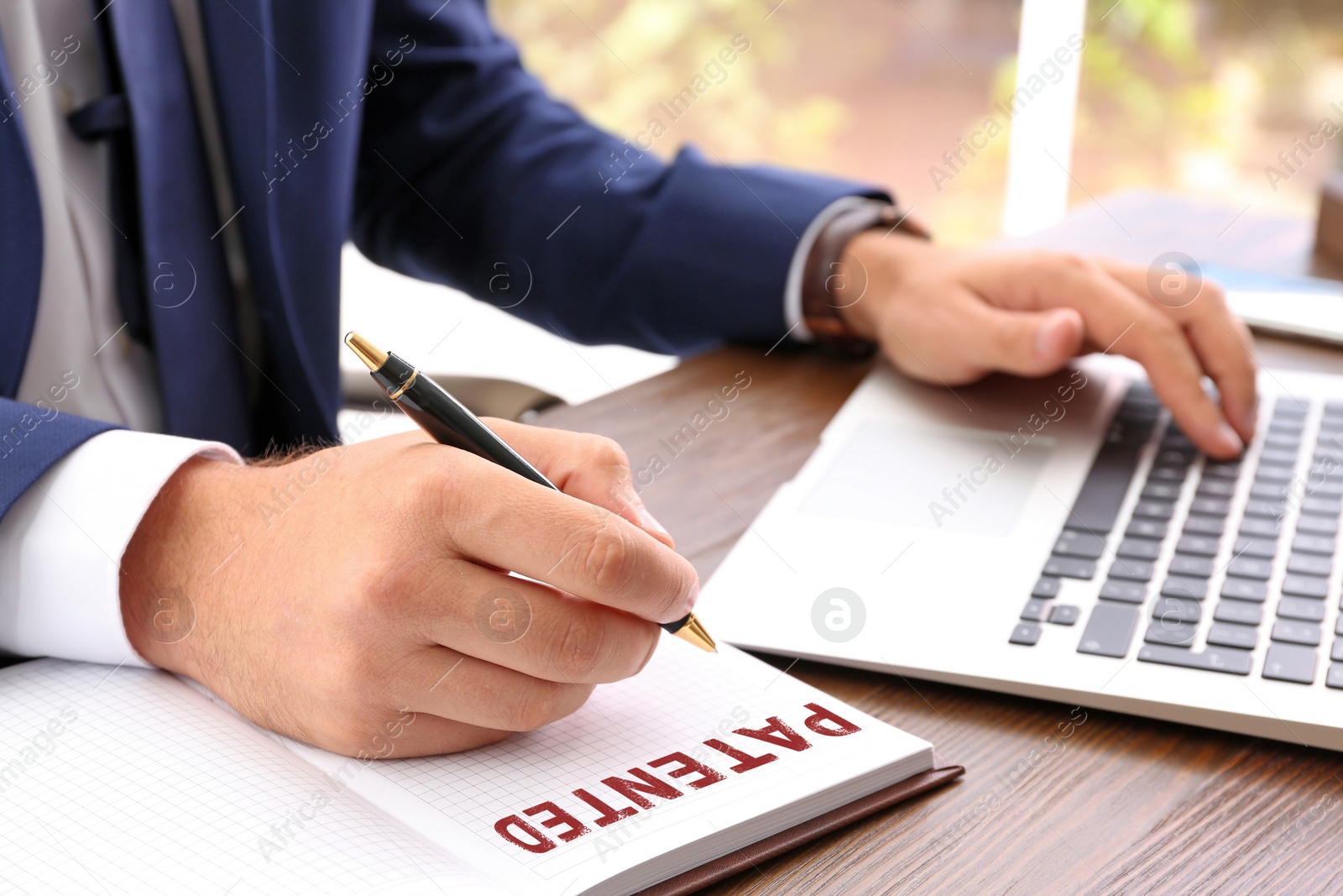 Image of Businessman working at table, closeup. Patent concept