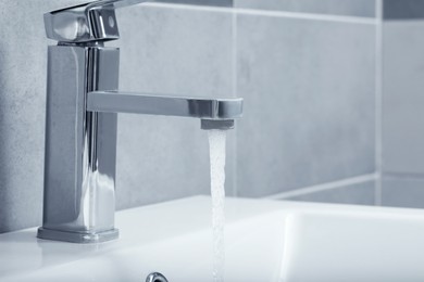 Photo of Stream of water flowing from tap in bathroom