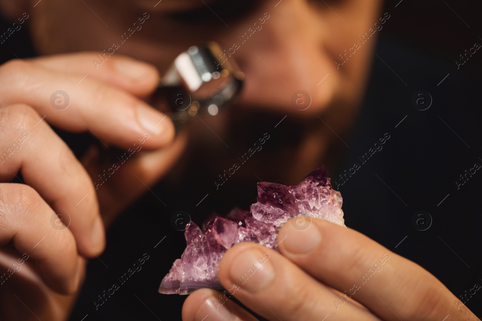 Photo of Jeweler working with gemstone on blurred background, closeup