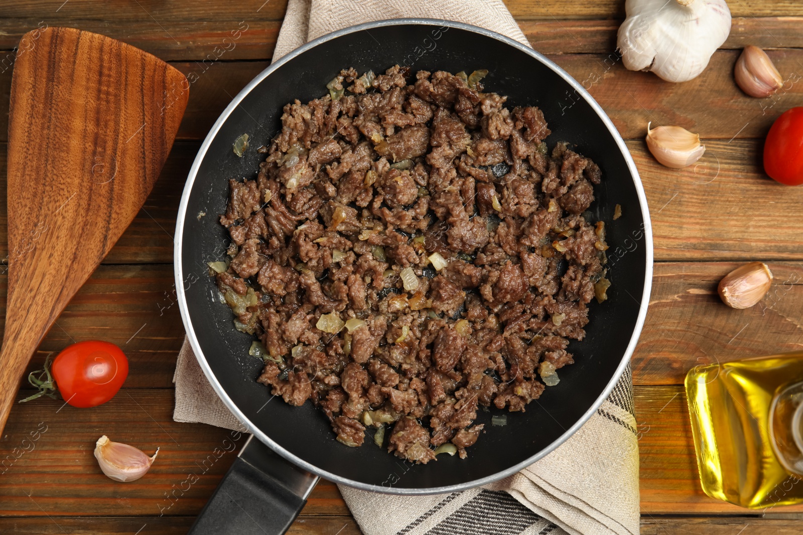 Photo of Fried minced meat with onion served on wooden table, flat lay