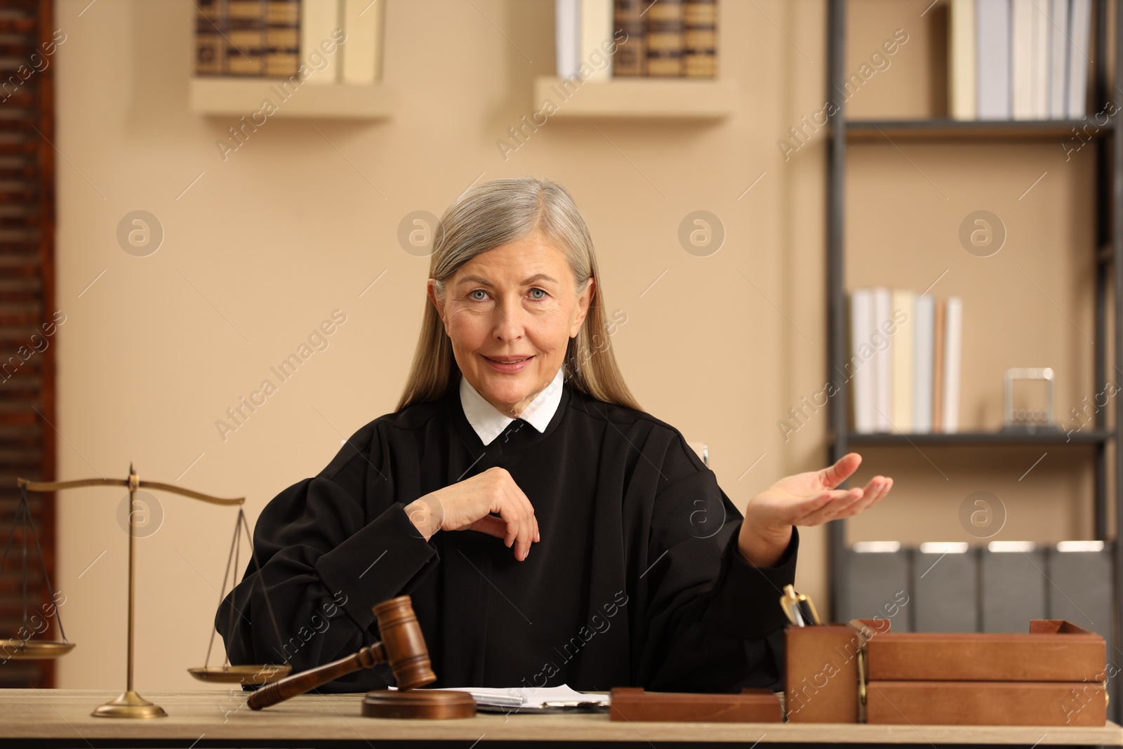 Photo of Judge in court dress working at table indoors