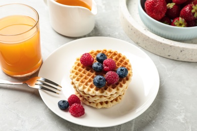 Photo of Tasty breakfast with wafers served on light grey marble table