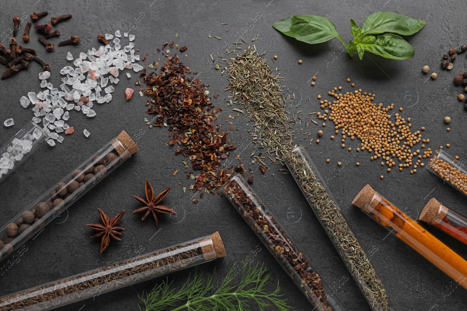 Photo of Flat lay composition with various spices, test tubes and fresh herbs on grey background