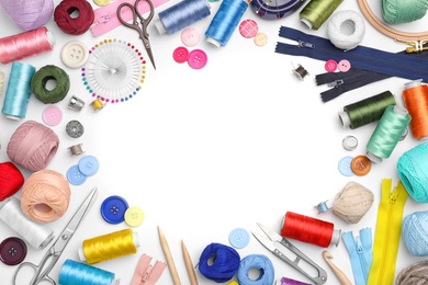 Photo of Composition with color threads and sewing accessories on white background, top view