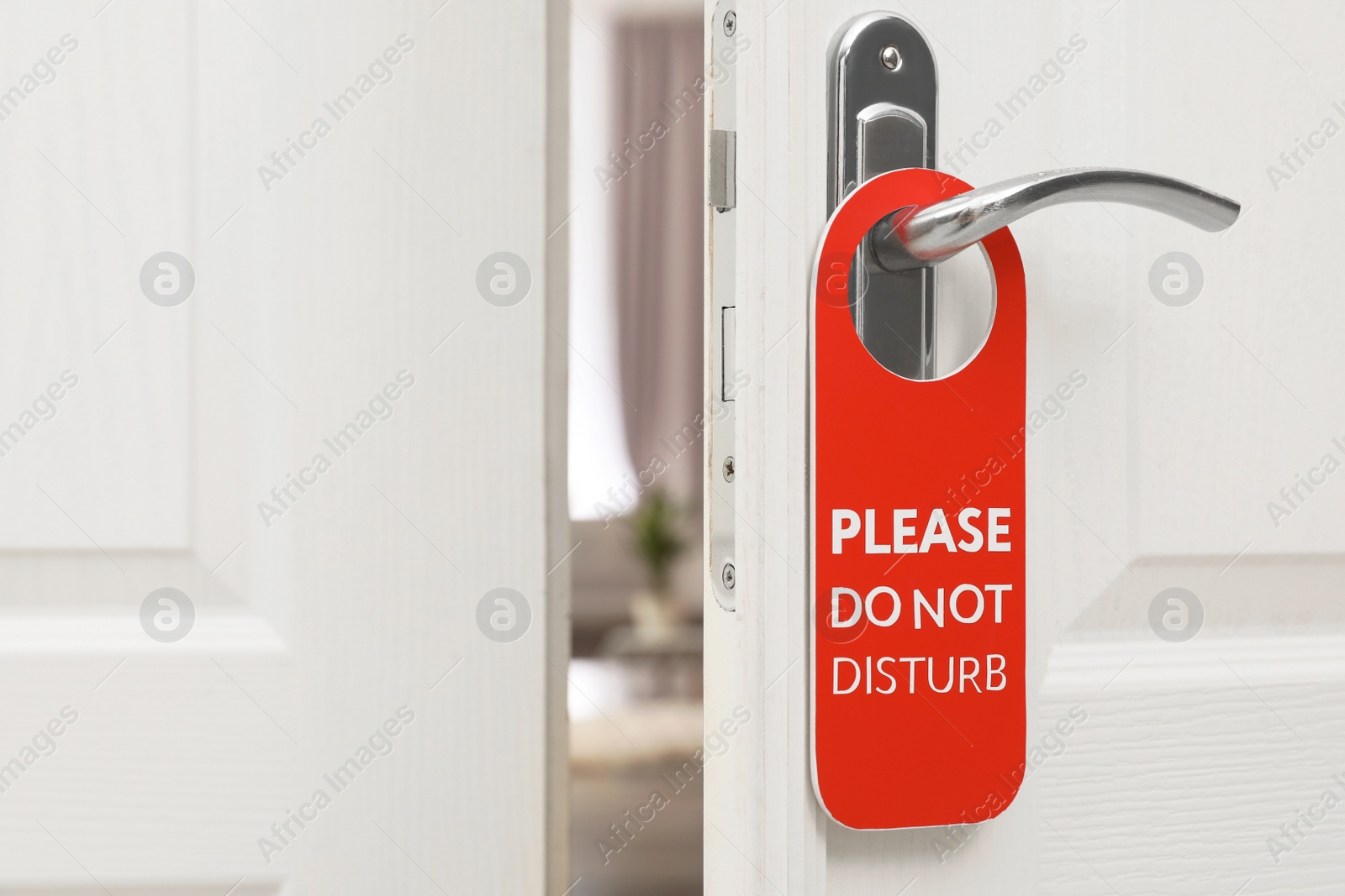 Photo of Open door with sign PLEASE DO NOT DISTURB on handle at hotel