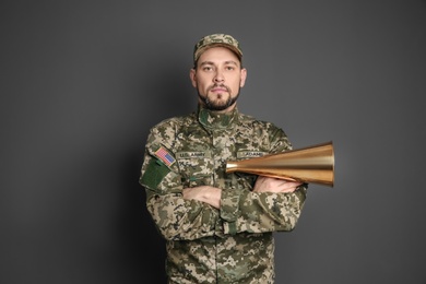 Photo of Military man with megaphone on gray background