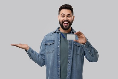 Photo of Happy young man with blank badge on grey background