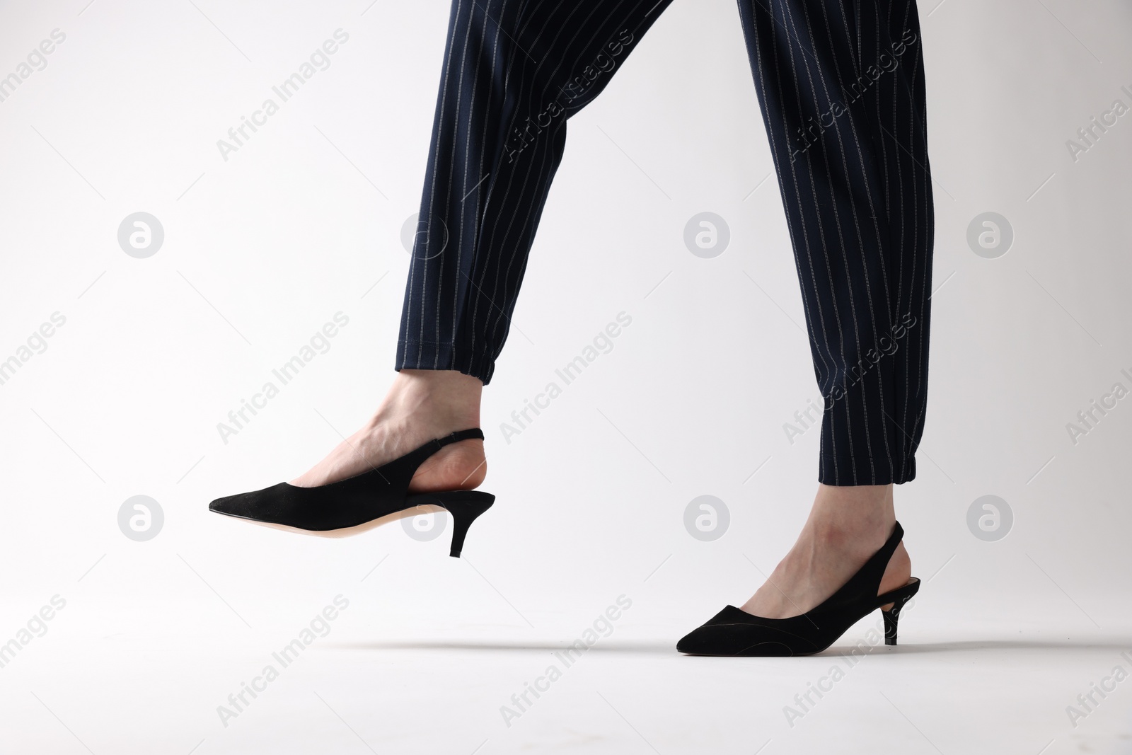 Photo of Businesswoman in black shoes on white background, closeup