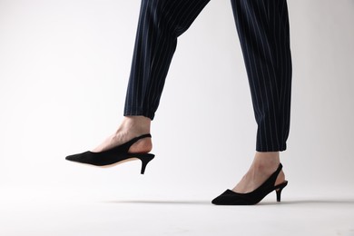 Photo of Businesswoman in black shoes on white background, closeup