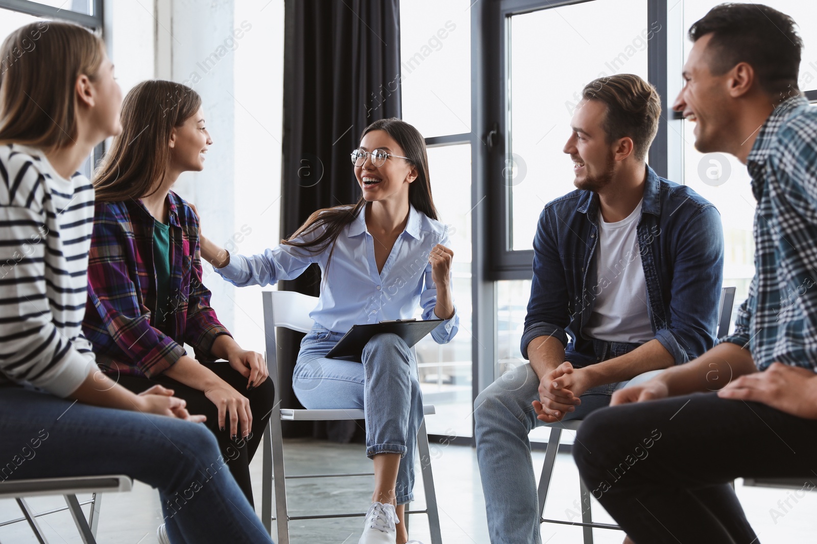 Photo of Psychotherapist working with patients in group therapy session indoors