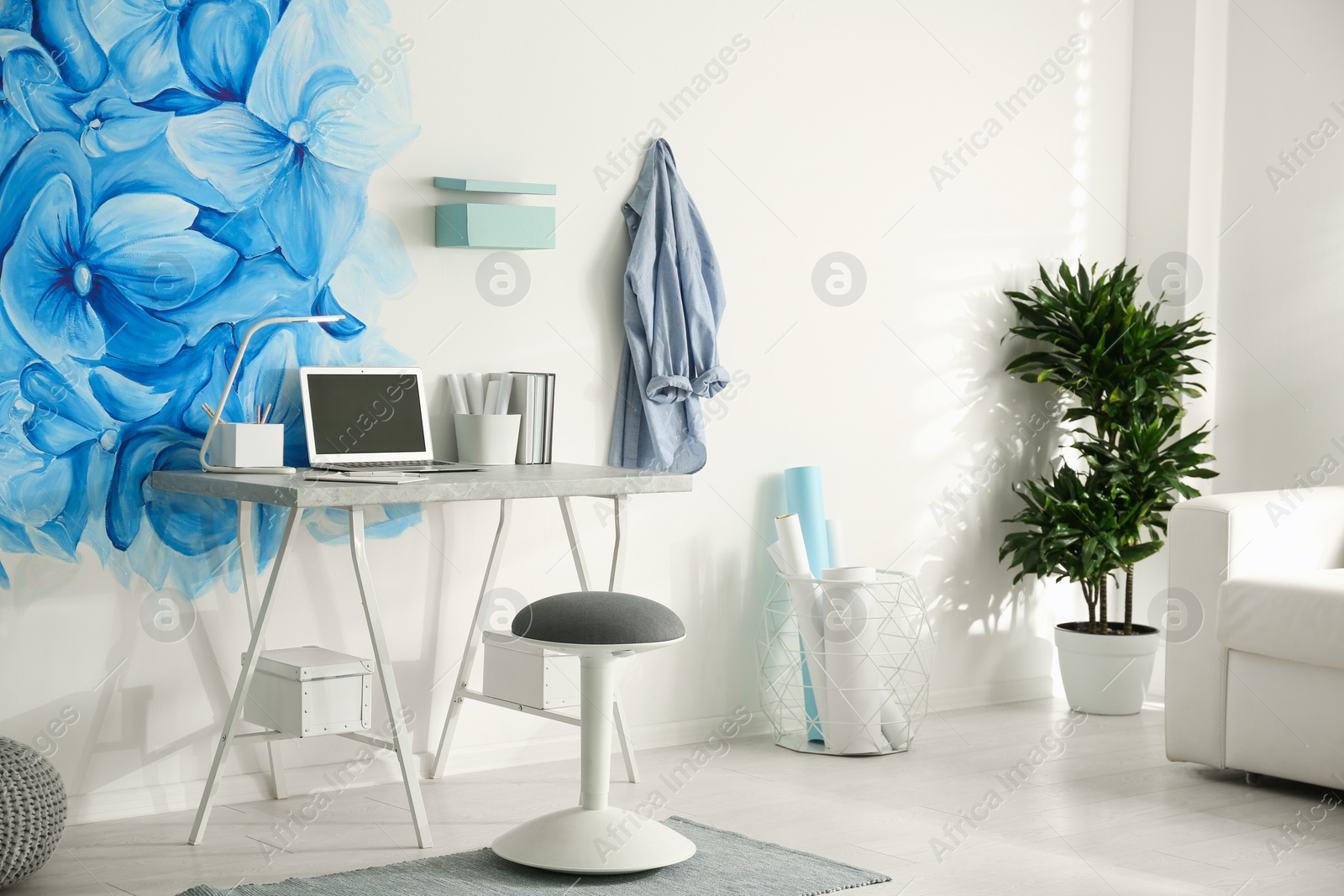 Photo of Stylish living room interior with blue flowers painted on wall. Floral pattern