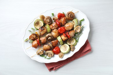 Delicious shish kebabs with vegetables and microgreens on white table, top view