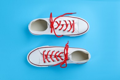 Photo of Pair of trendy sneakers on light blue background, flat lay