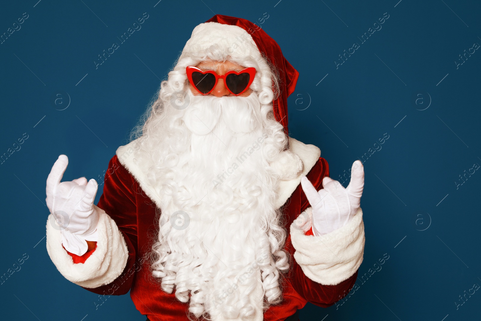 Photo of Authentic Santa Claus wearing sunglasses on blue background