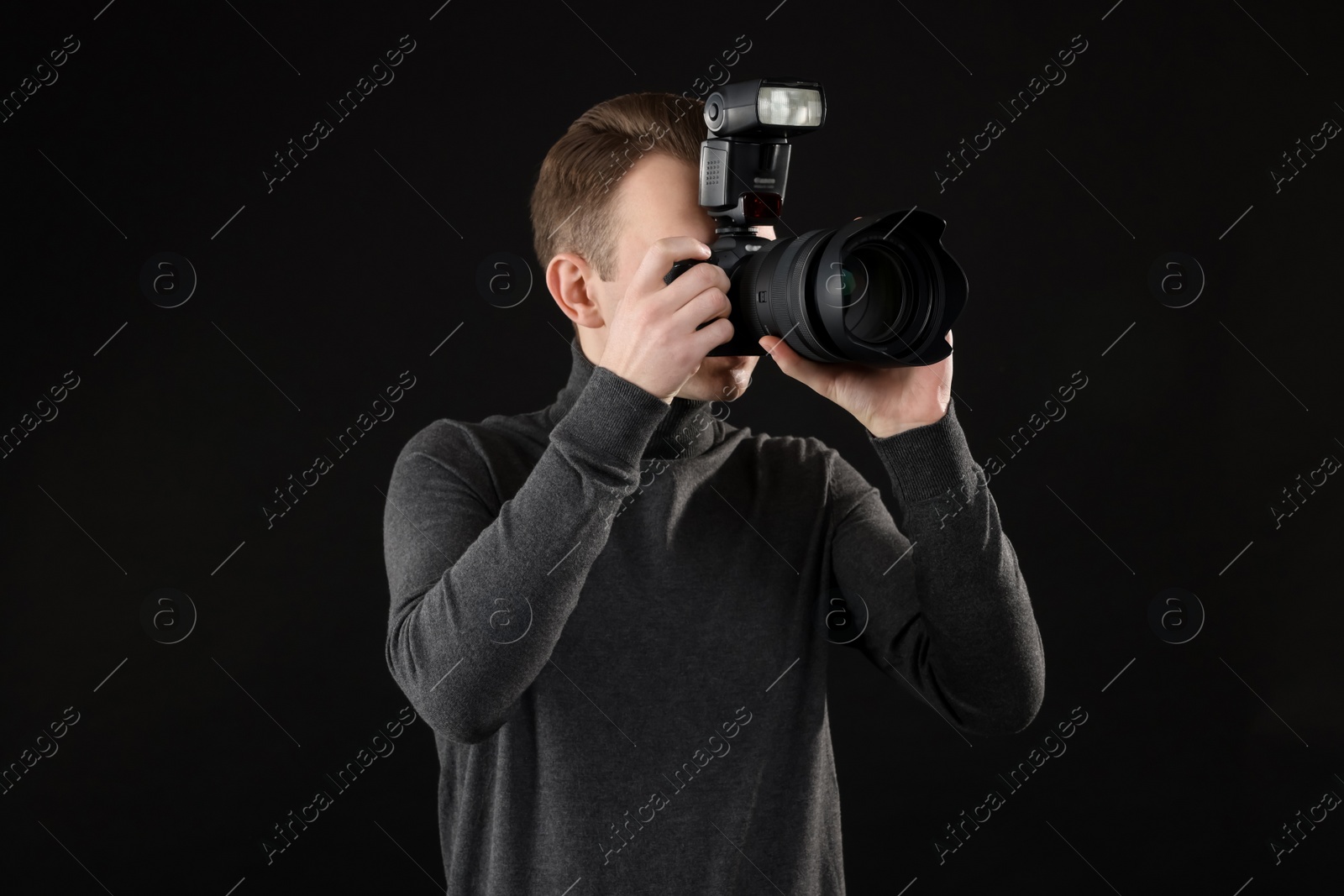 Photo of Professional photographer taking picture on black background