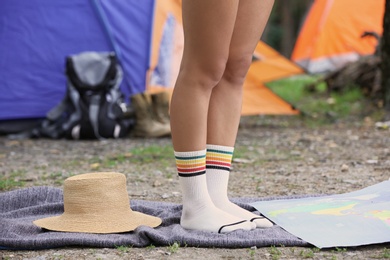 Photo of Woman in socks near near camping tent outdoors, focus on legs
