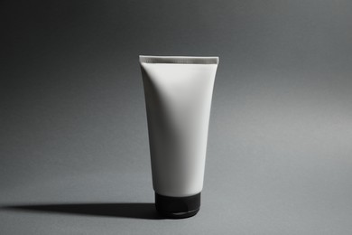 Tube of men's facial cream on grey background. Mockup for design