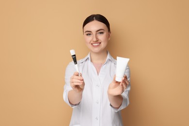 Photo of Cosmetologist with cosmetic product and brush on beige background