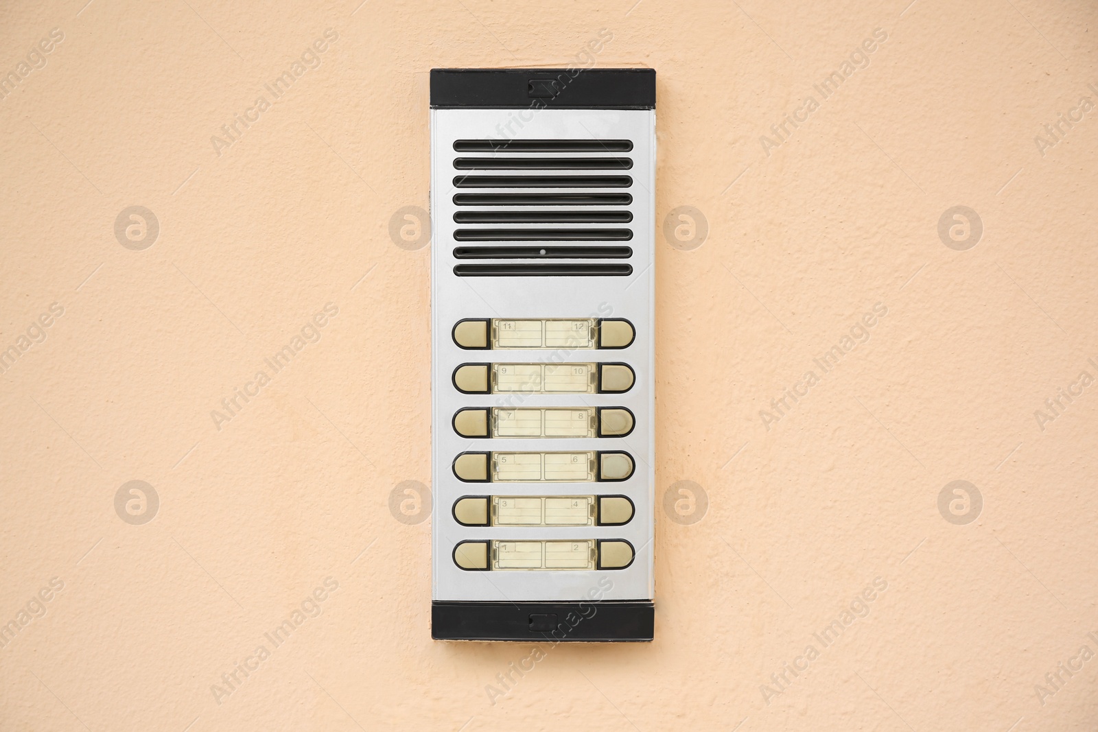 Photo of Modern intercom on beige wall. Security system