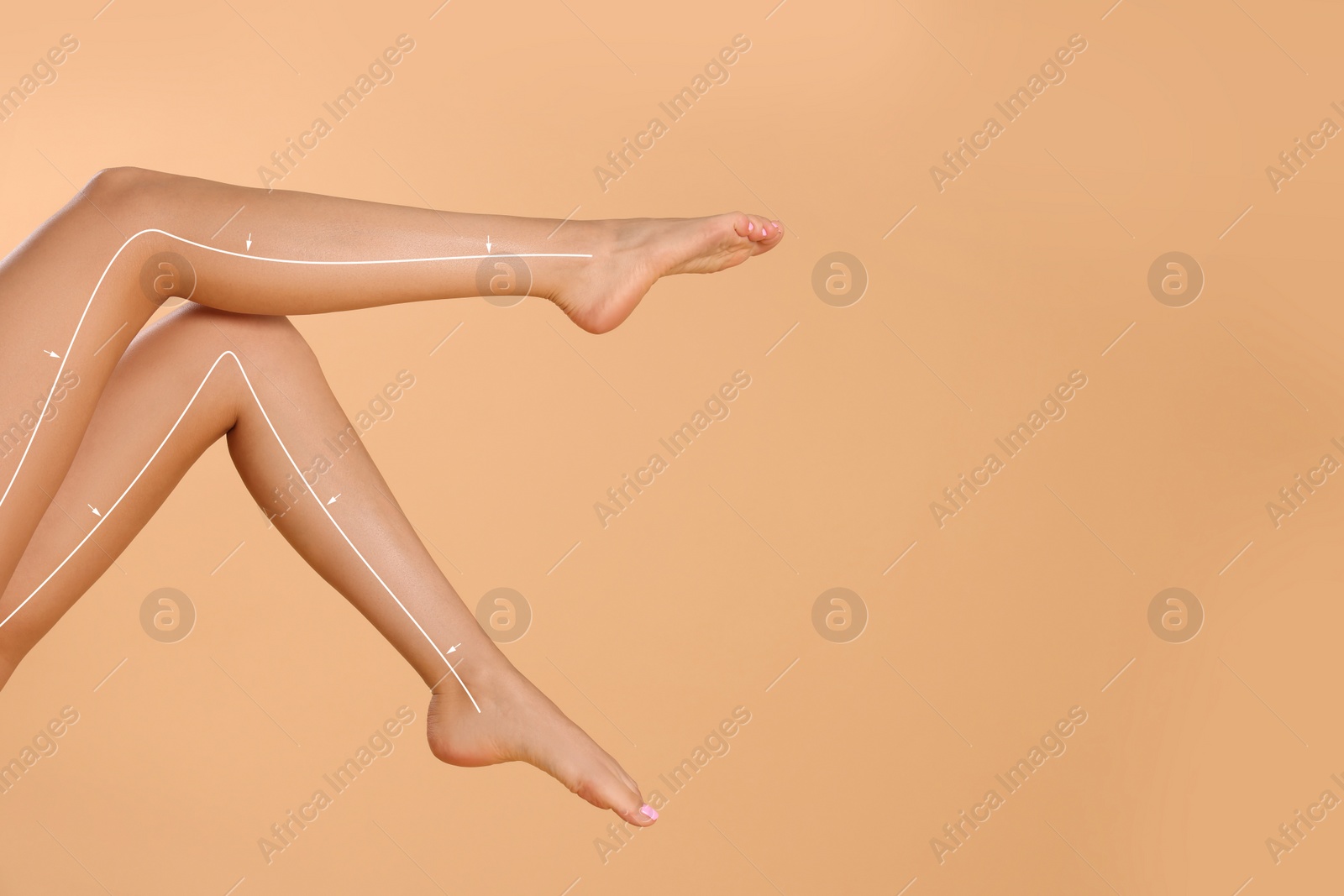 Image of Epilation guide - how to remove hair in proper direction. Woman with drawn lines and arrows on her beautiful smooth legs against pale orange background