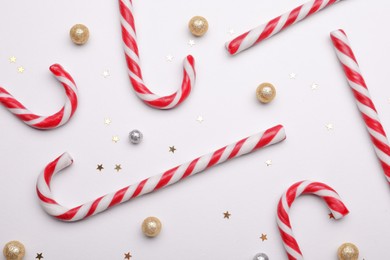 Photo of Many sweet Christmas candy canes and decor on white background, flat lay