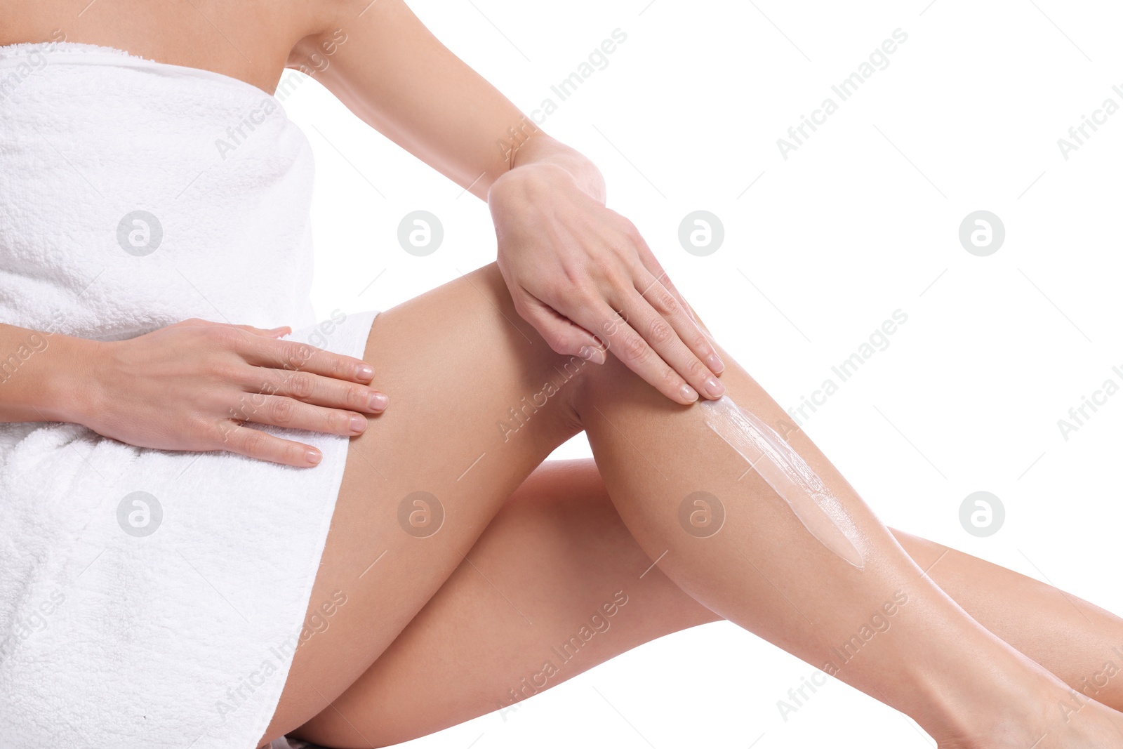 Photo of Woman applying body cream onto her leg against white background, closeup