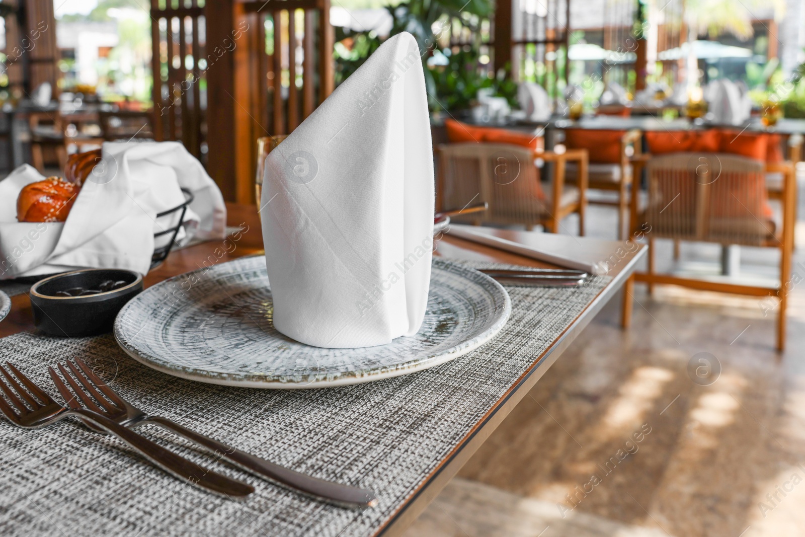 Photo of Dishware and cutlery on table in cafeteria, closeup