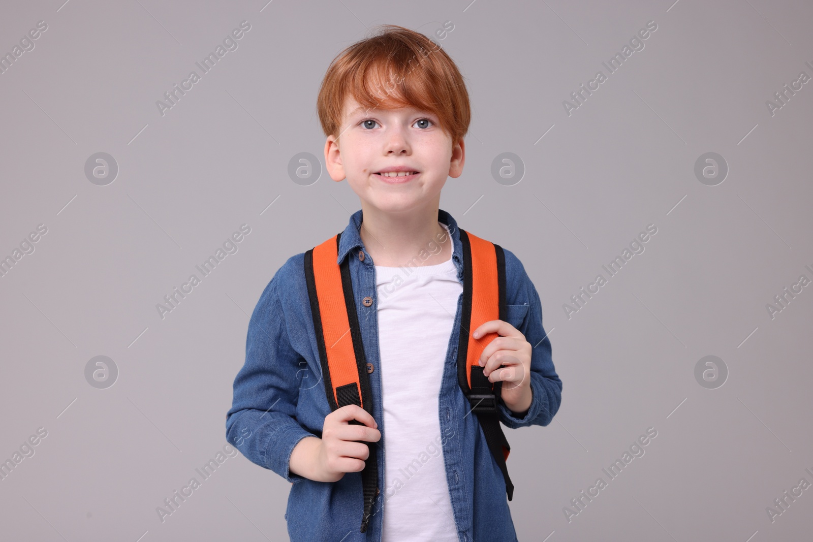 Photo of Portrait of happy schoolboy on grey background