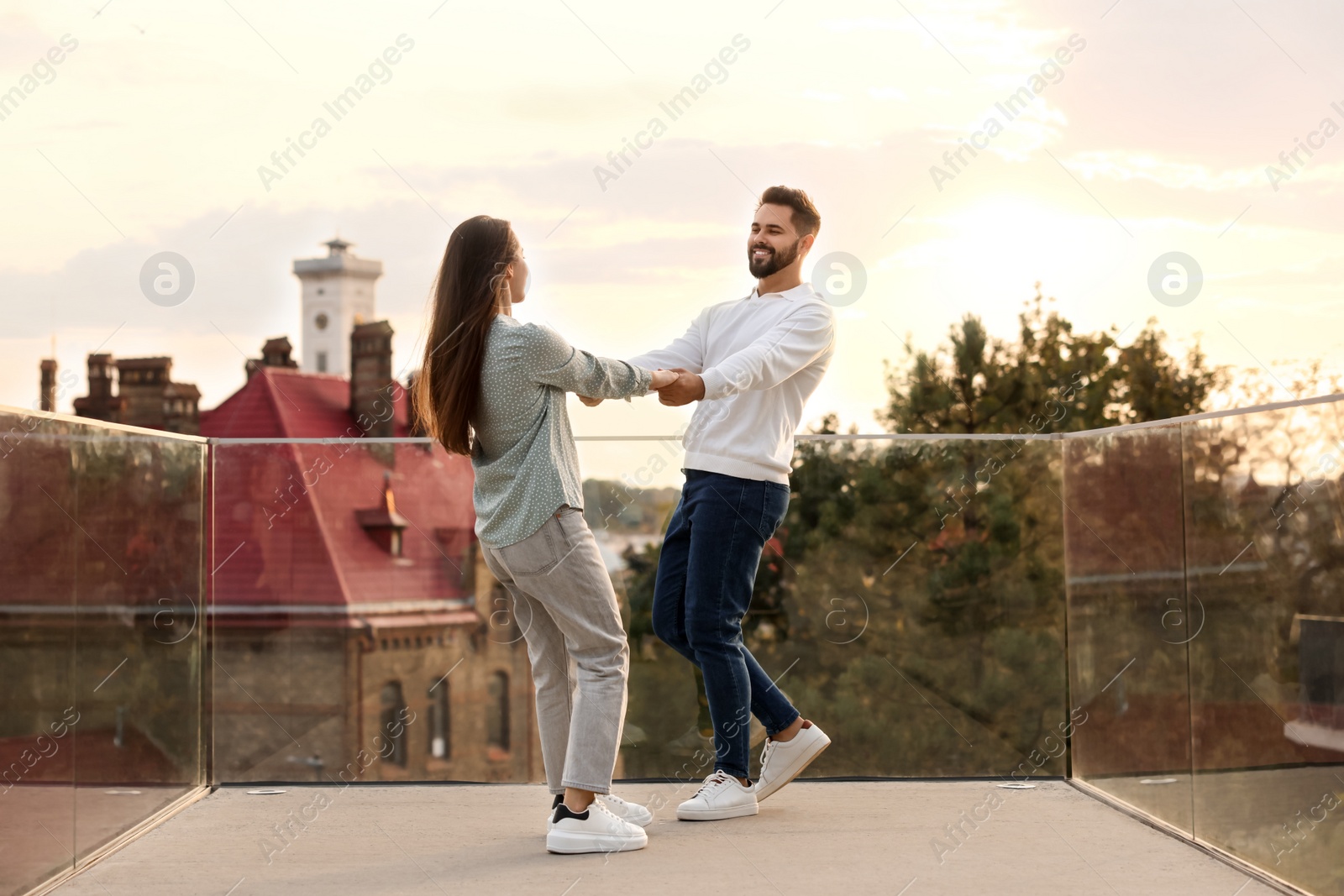 Photo of Lovely couple dancing together outdoors at sunset