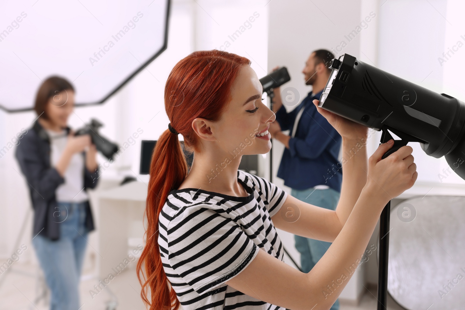 Photo of Young professional photographers working in modern photo studio