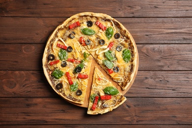 Photo of Board with delicious homemade pizza on wooden background, top view