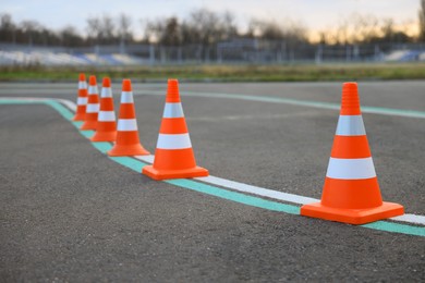 Photo of Driving school test track with marking lines, focus on traffic cone